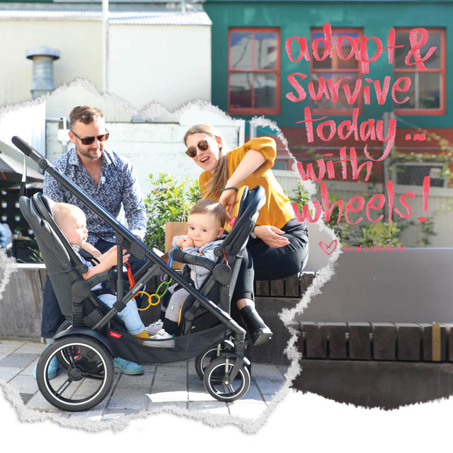 parents interacting with two toddlers sitting face to face using voyager inline buggy made by philandteds